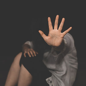 Sex Crimes: A person shielding their face with an outstretched hand, representing the impact of serious charges.