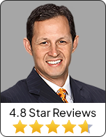 Professional headshot of a smiling male attorney in a suit with a 4.8-star rating graphic