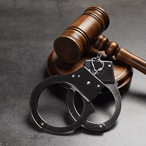 Handcuffs and a judge's gavel on a table: legal process for filing a motion to recuse a judge.