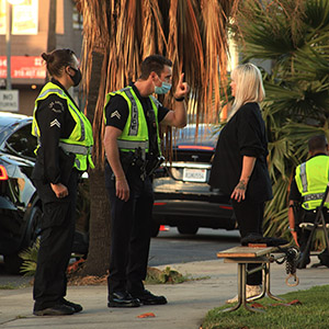 Police officers conducting a field investigation near a vehicle, illustrating the use of NarcoPouch drug tests.